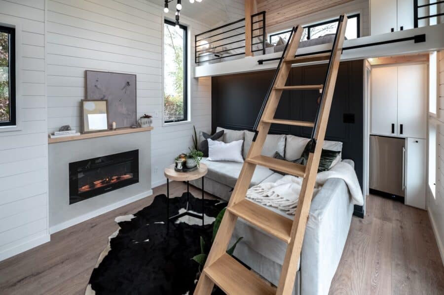 Cozy tiny house interior with loft bedroom and modern decor.