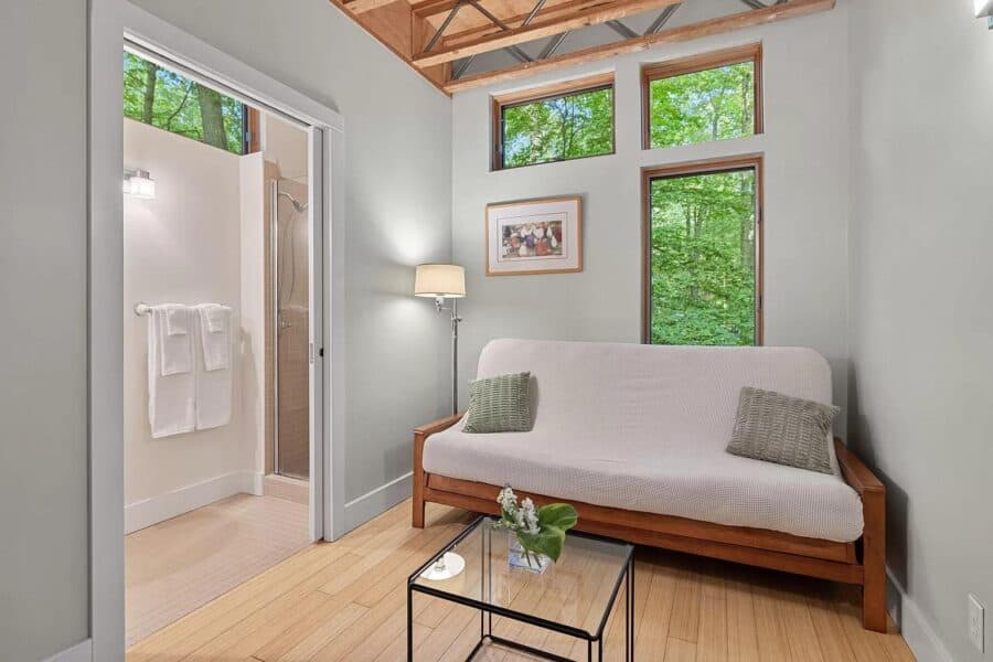 Cozy cabin living room with large windows and minimalist decor in Tryon Farms community.