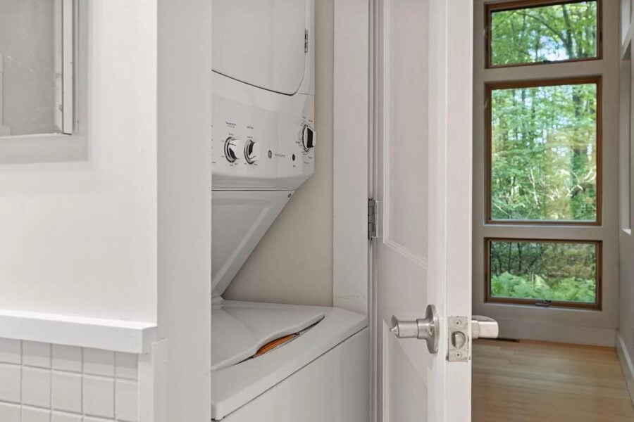Compact laundry nook inside a tiny house with washer and dryer.