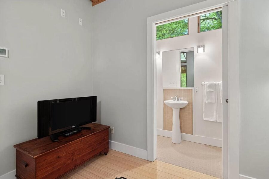 Cozy modern cabin bathroom with a pedestal sink and natural light at Tryon Farms community.