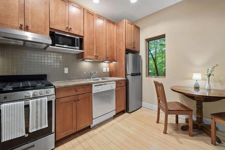 Cozy kitchen in a modern cabin at Tryon Farms community, featuring wooden cabinets, stainless steel.
