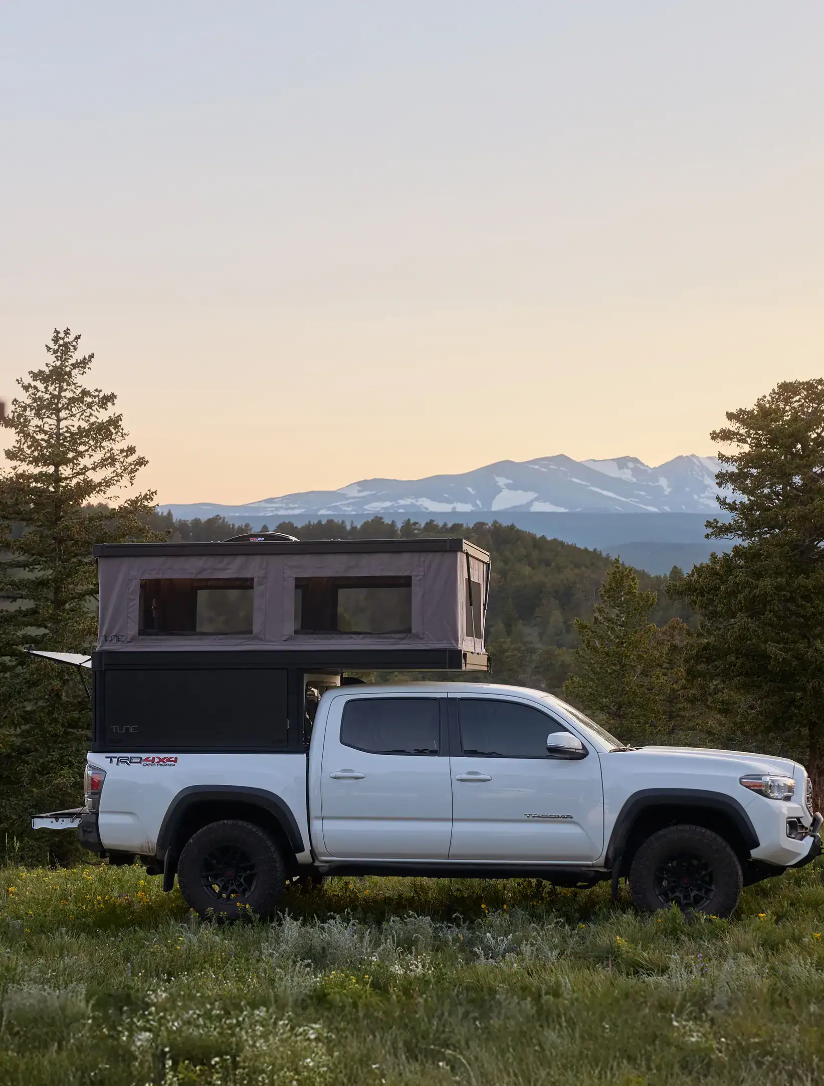 Tune M1L smaller truck bed camper model in field setting