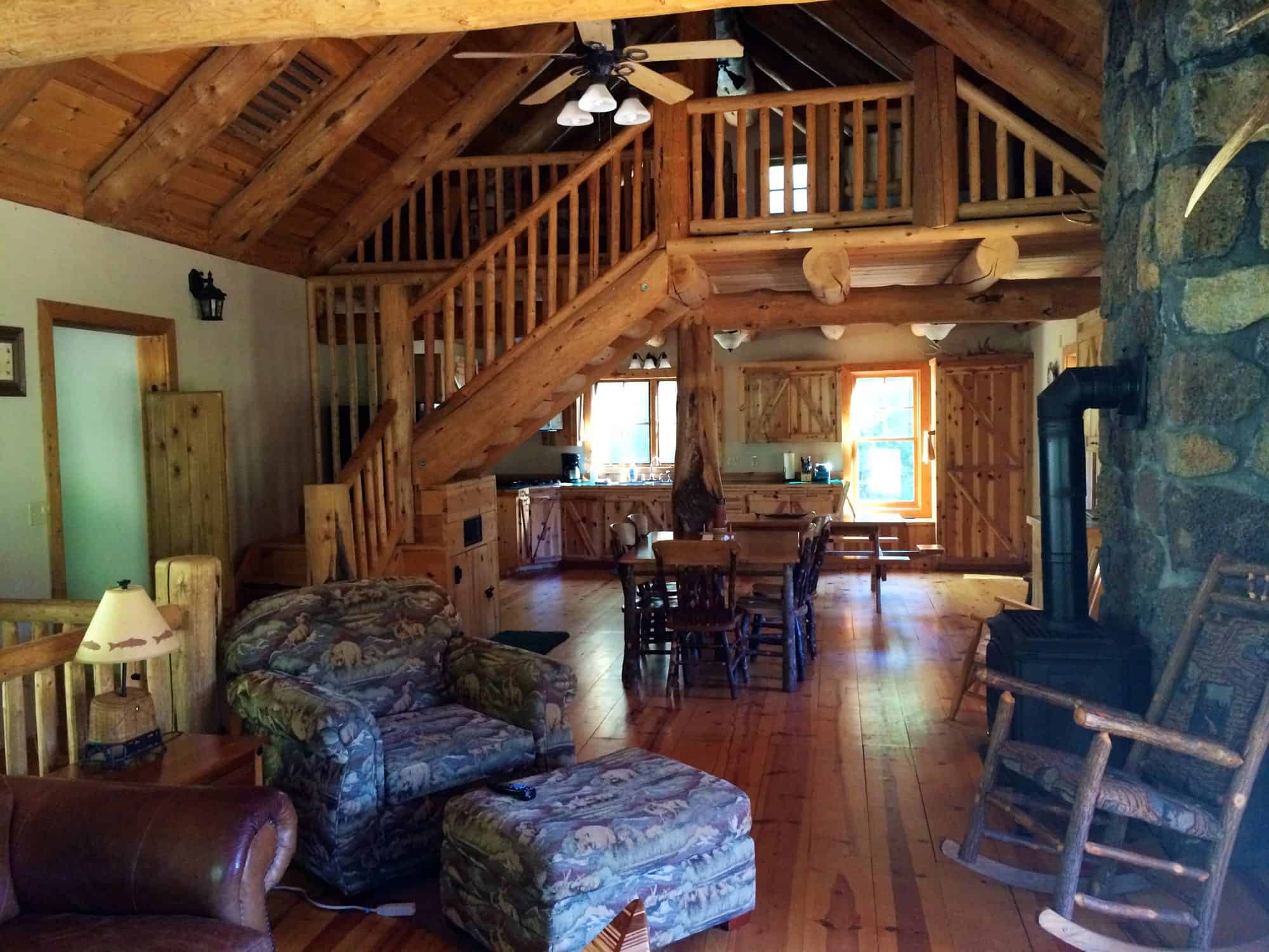 Log staircase leading up to the open loft above the living and dining area of the Tygh Valley cabin
