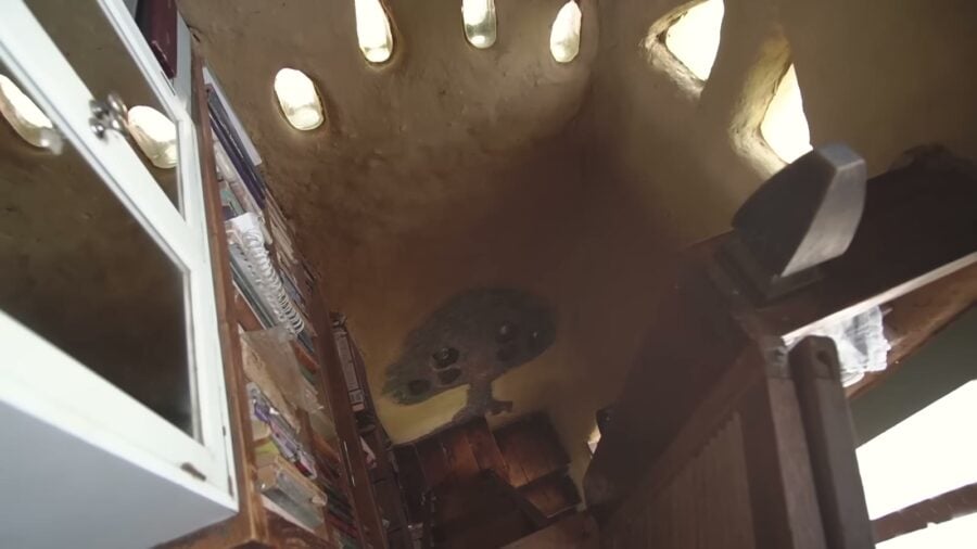 Looking up into the sleeping loft of the original 10x10 cob bunkie with glass bottle windows