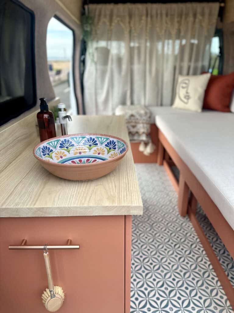 Interior van conversion with a colorful decorative bowl on a wooden counter.