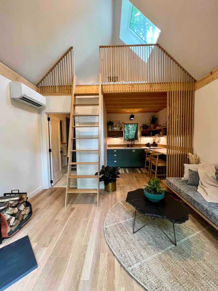 Wooden loft tiny house with open living space and modern kitchen.