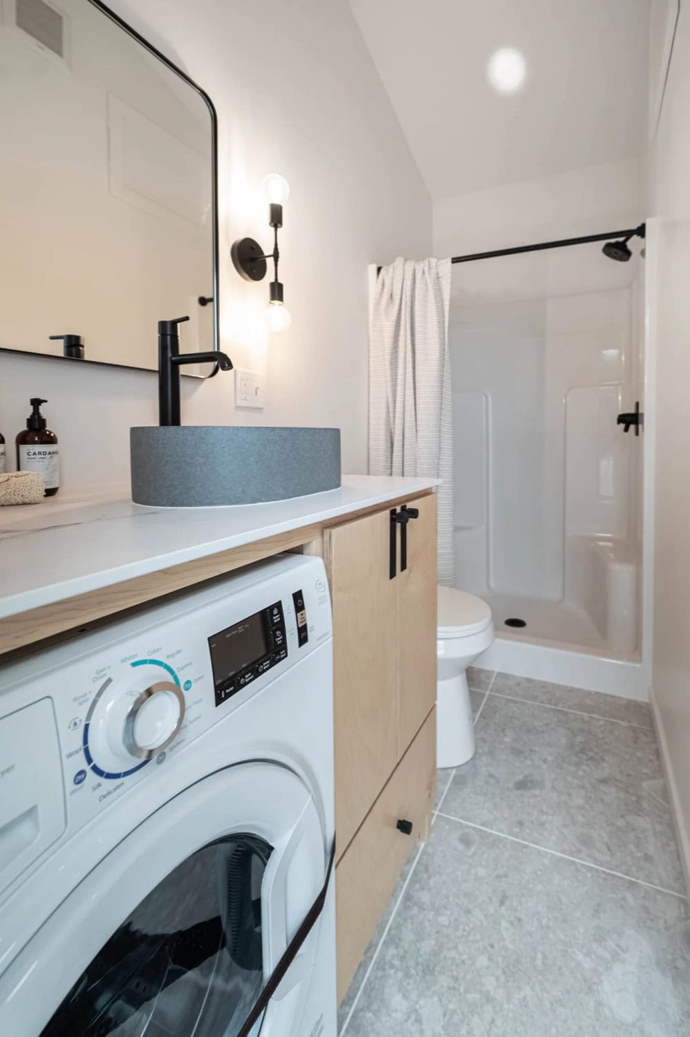 Urban Gable Park bathroom shower with matte-black fixtures and terrazzo tile floor
