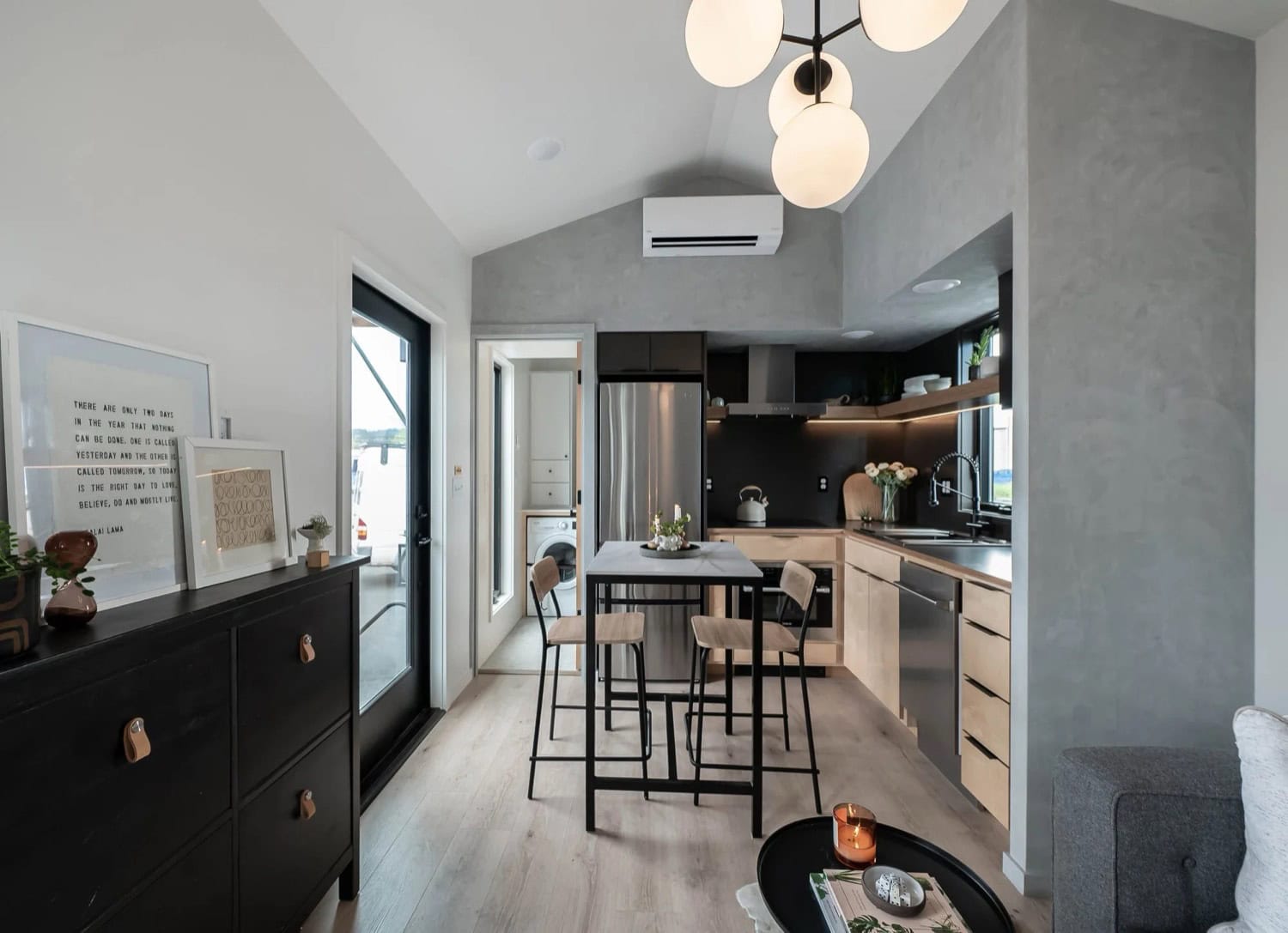 Open living and kitchen area in the Urban Gable Park with vaulted ceiling and globe chandelier