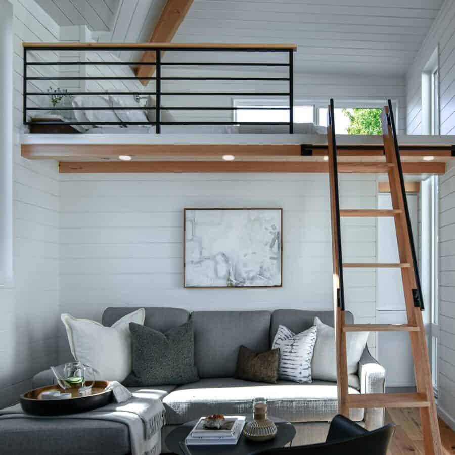 Cozy tiny house interior with loft and modern decor.