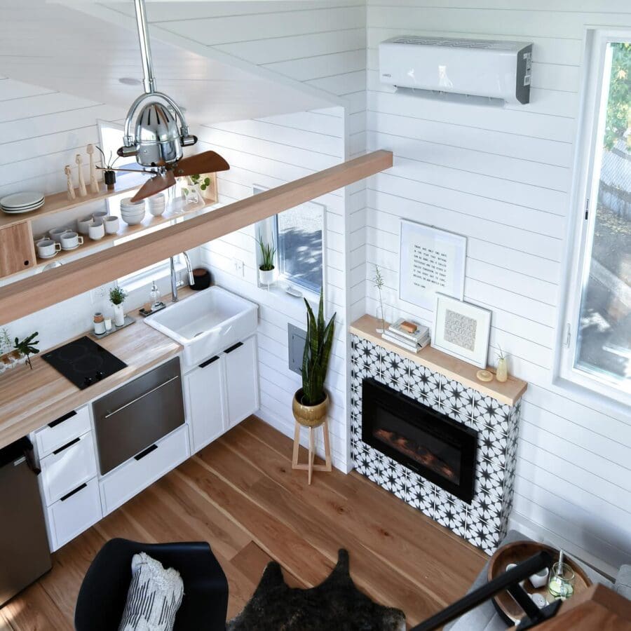 Compact tiny house kitchen with modern appliances and stylish decor.