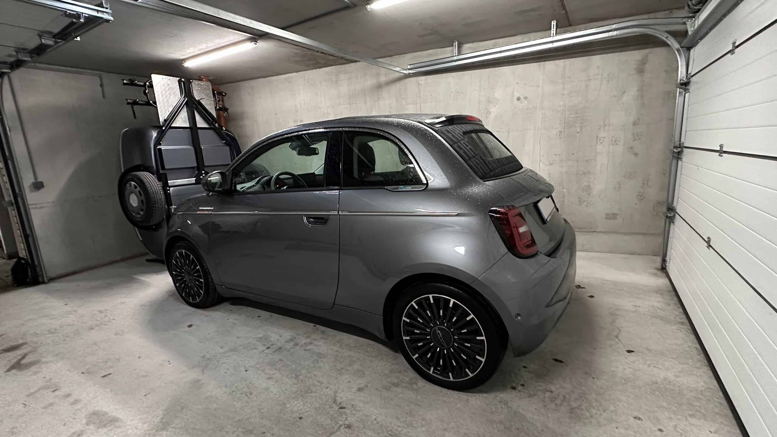 Fiat 500 parked in a single garage alongside the vertically stored Urbanoid Booba trailer