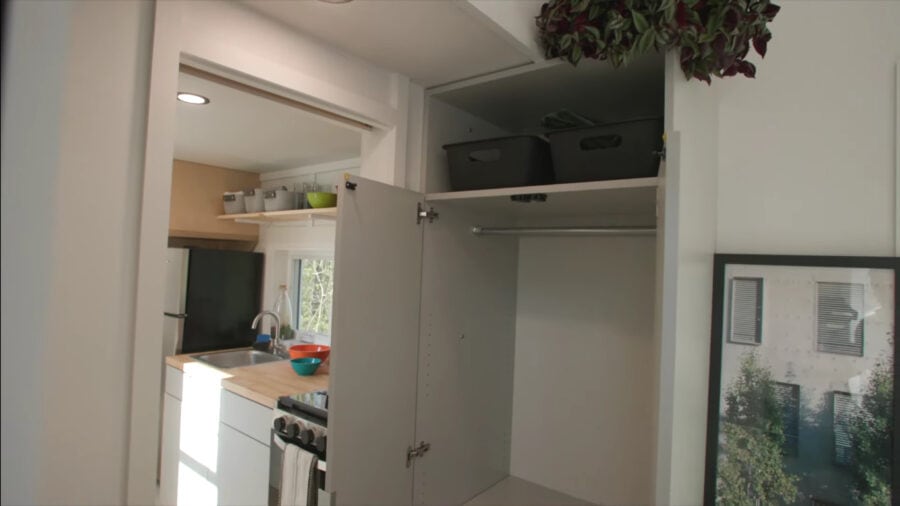 Interior view of a tiny home showing storage cabinets and kitchen area.