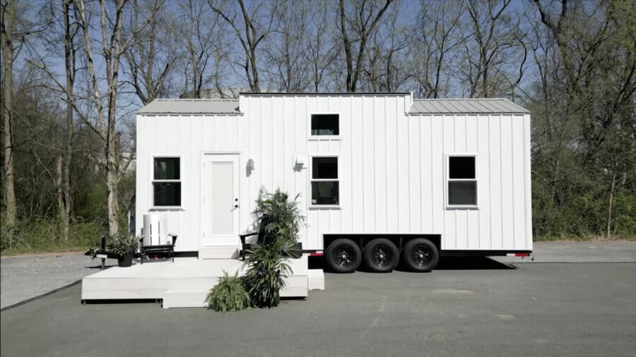 Modern 28-ft tiny house on wheels with first-floor bedroom and sleek exterior.