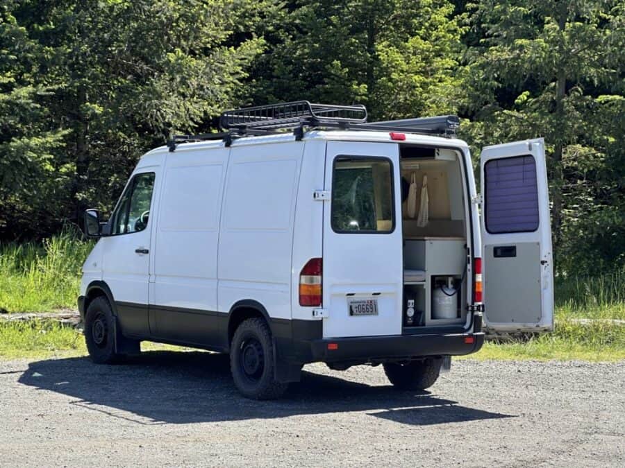 Van conversion with minimalist kitchen and solar setup.