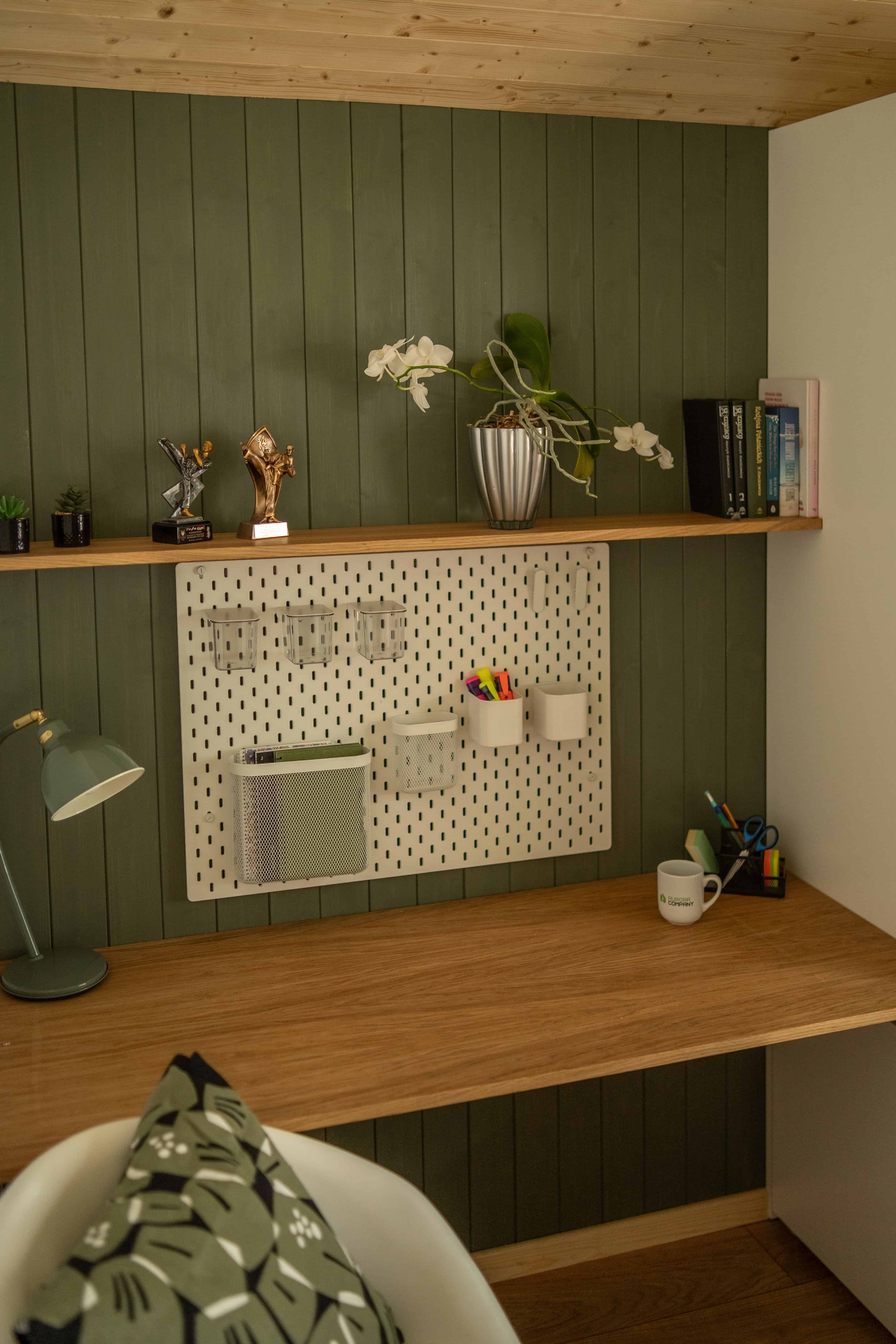 The second bedroom of the Vagabond Haven Evergreen set up as a home office with a desk and pegboard