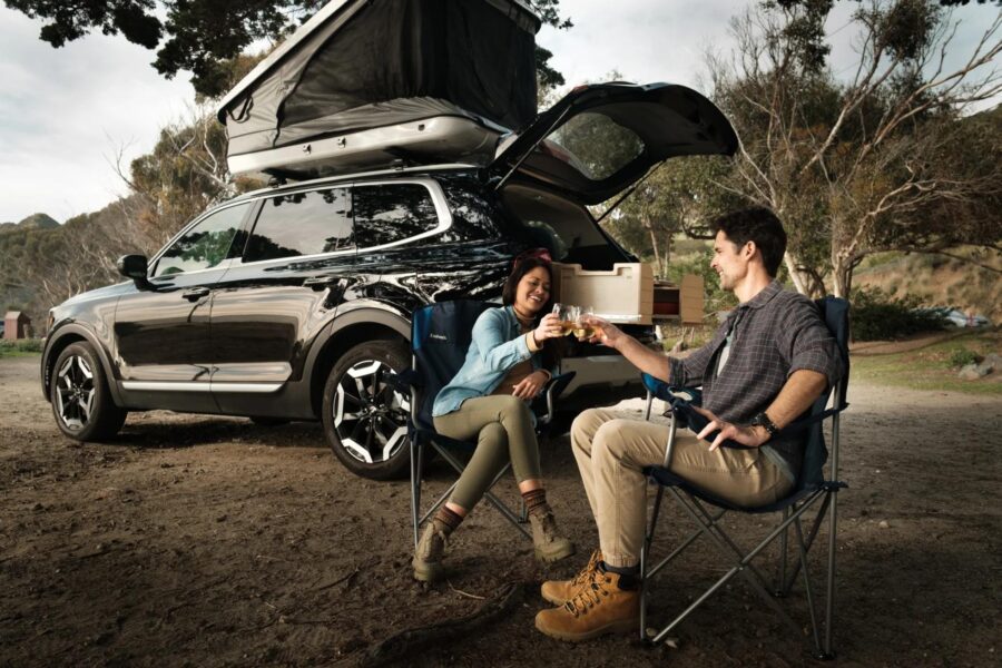 Compact SUV with VanLab conversion kit, outdoor camping scene with two people.
