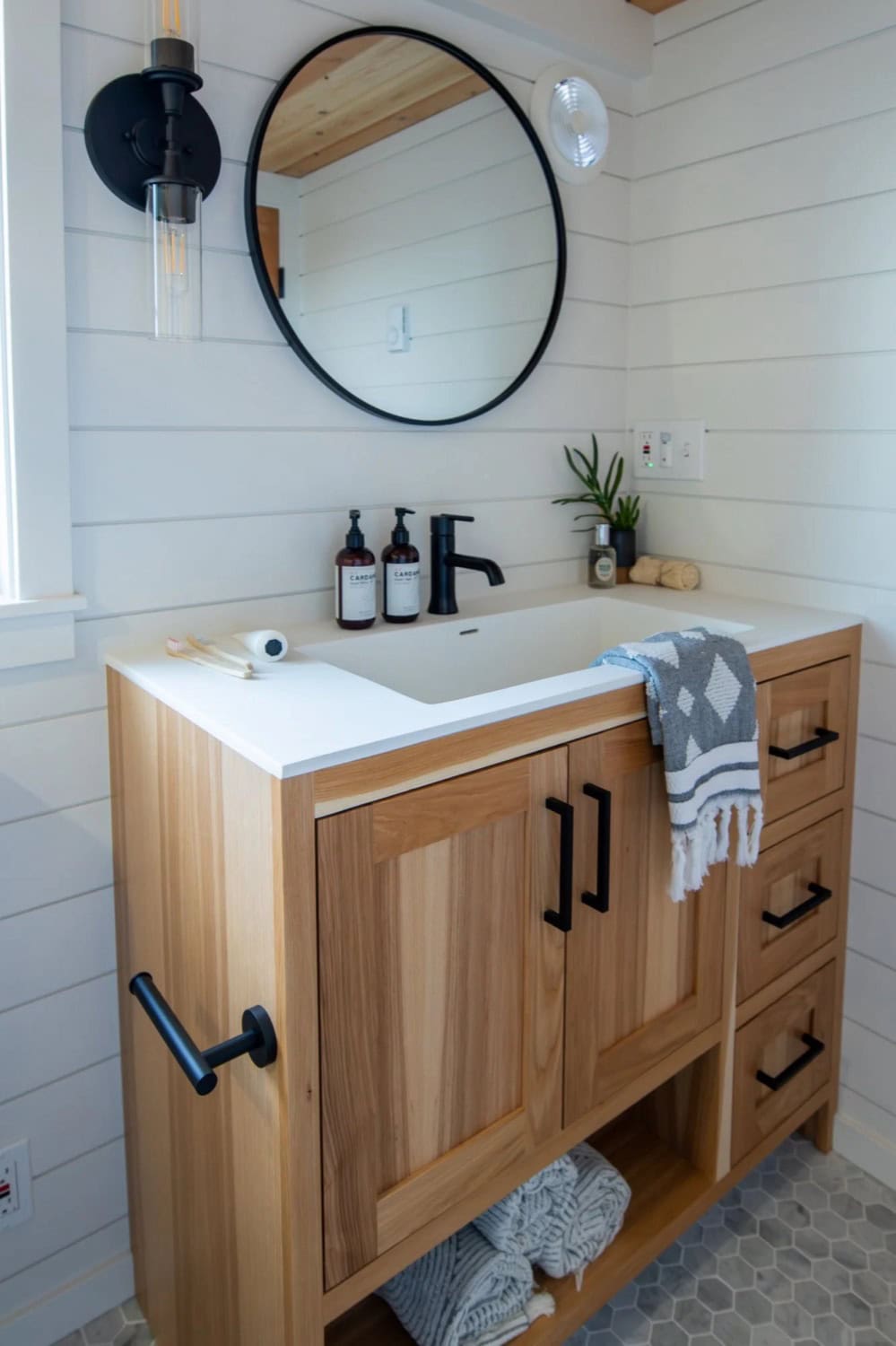 Villa Max bathroom vanity with wood cabinet, round mirror and matte black fixtures