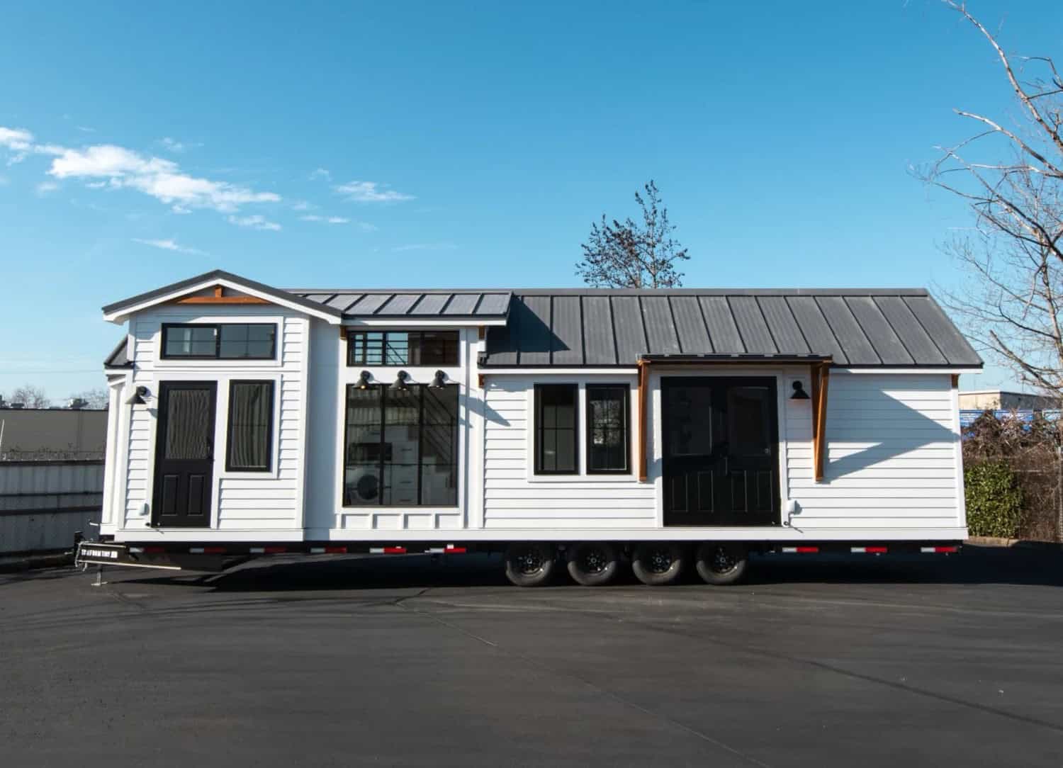 Villa Max farmhouse park model tiny home by Tru Form Tiny with white board-and-batten siding and a black standing-seam roof