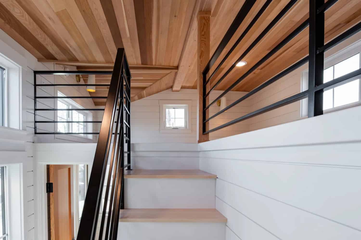 Sleeping loft in the Villa Max with wood cathedral ceiling and black metal railings