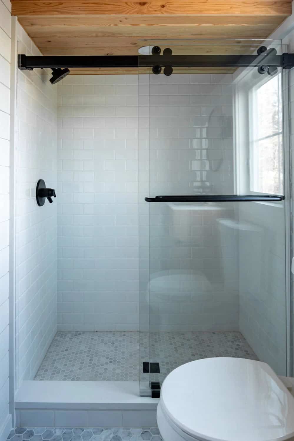 Walk-in shower in the Villa Max with white subway tile and a sliding glass door