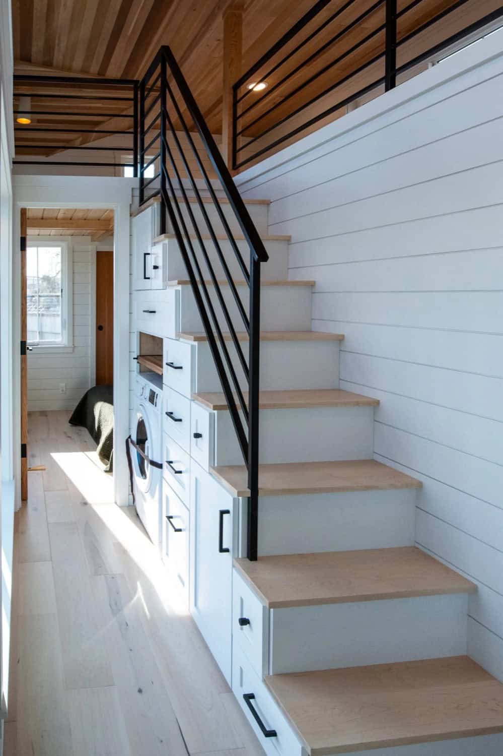 Villa Max staircase with built-in drawer storage and integrated stacked washer and dryer