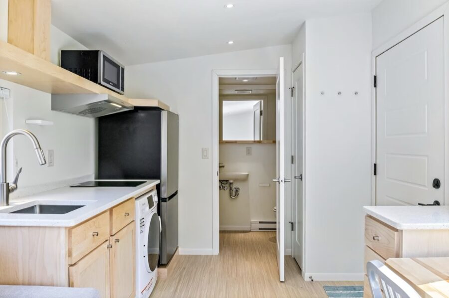 Compact tiny house kitchen with modern appliances and minimalist design.