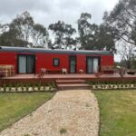 Tiny house on wheels with a spacious deck and modern design in Australia.