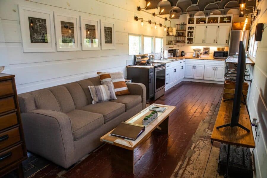 Cozy tiny house kitchen with white cabinets and wooden accents.