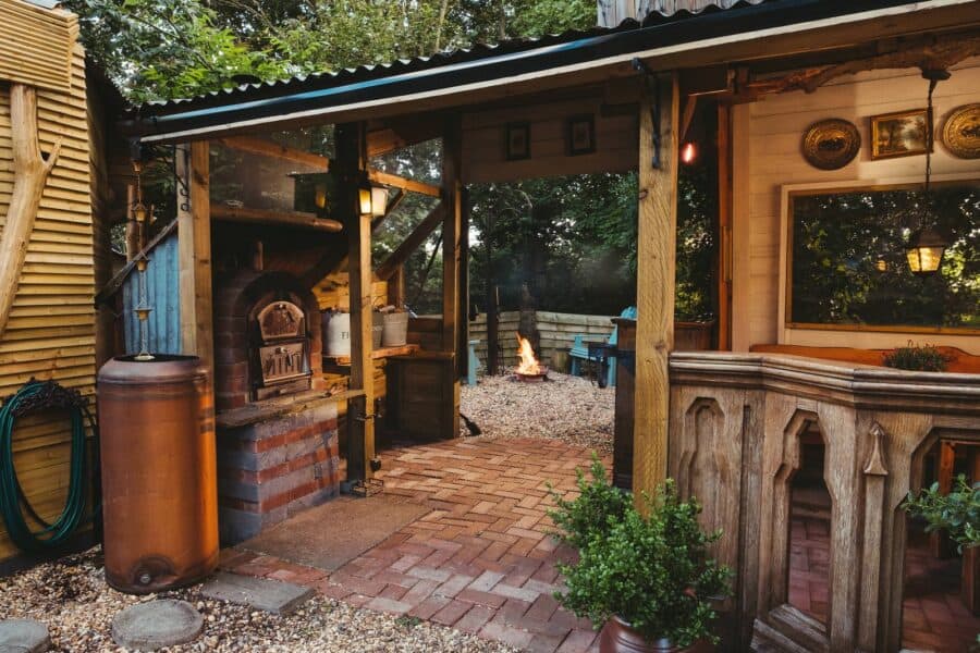 Covered outdoor saloon dining area with pizza oven at the Wagon in the Woods