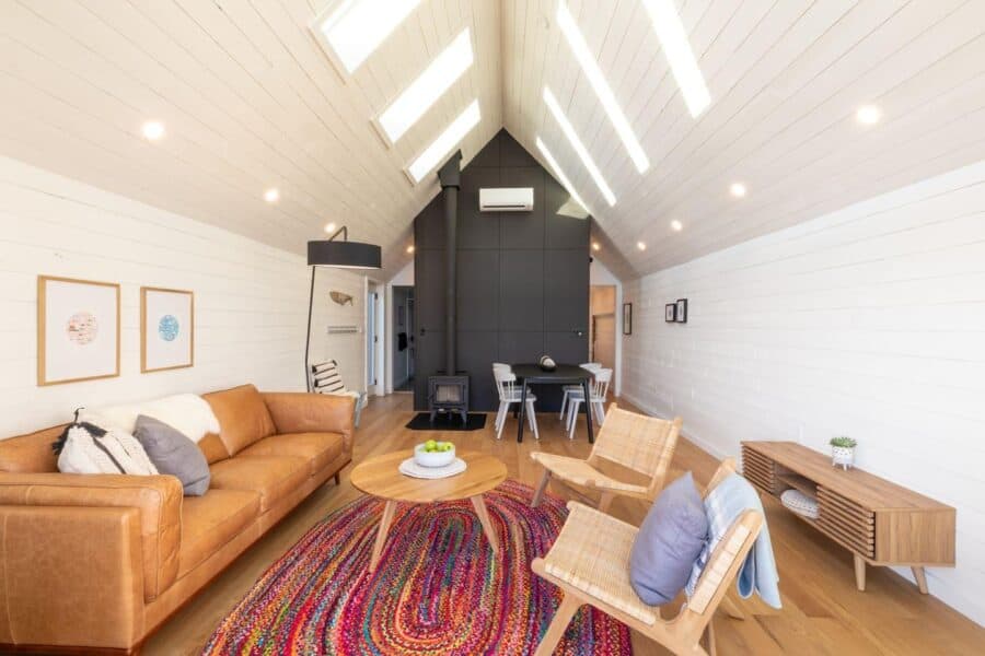 Bright Scandinavian waterfront cabin with modern black exterior and stargazing loft in Nova Scotia.