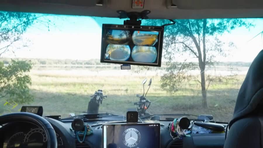 Interior view of a tiny van home built on a T1N Sprinter chassis with scenic outdoor background.