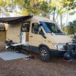 Van mansion tiny home on a T1N Sprinter chassis with outdoor setup.