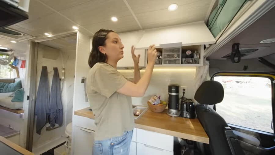 Interior view of a tiny van home with organized storage and modern amenities.