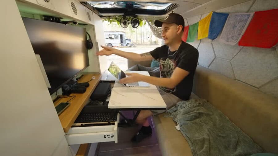 Compact van home interior featuring a workspace, meditation corner, and cozy seating in a custom-bui.