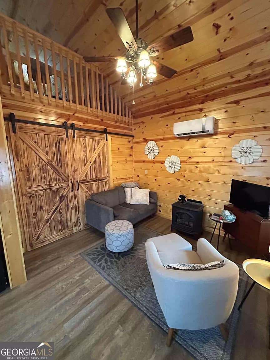Charming tiny house interior with wooden walls, comfortable seating, and rustic decor.