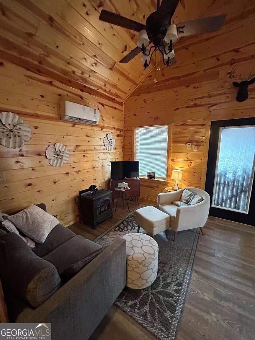 Cozy living room inside a whispering hills cabin with wooden walls, comfortable seating, and natural.