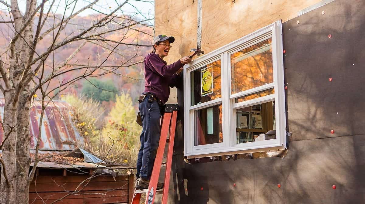 Students installing windows in a tiny house at the Wild Abundance workshop