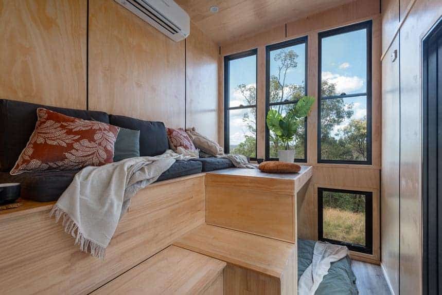 Raised living platform with full-height windows in the Wildscape tiny house