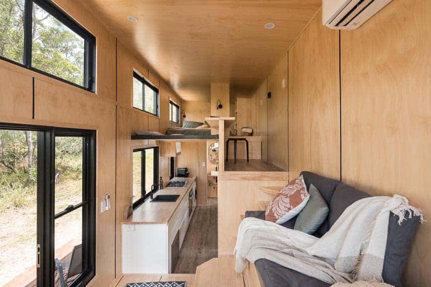 Custom lounge seating with storage stairs in the Wildscape tiny house living area