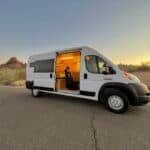 Van life camper van with cozy interior at sunset.