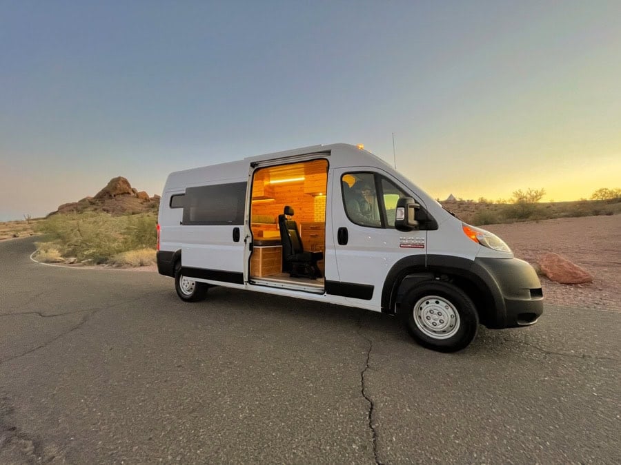Van life camper van with cozy interior at sunset.