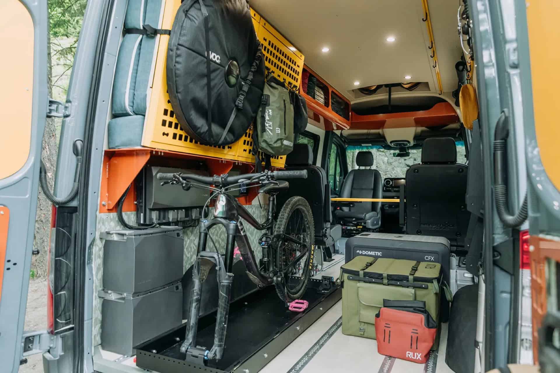 GB01 rear doors open in summer with a mountain bike on a slide-out tray and gear boxes on the floor