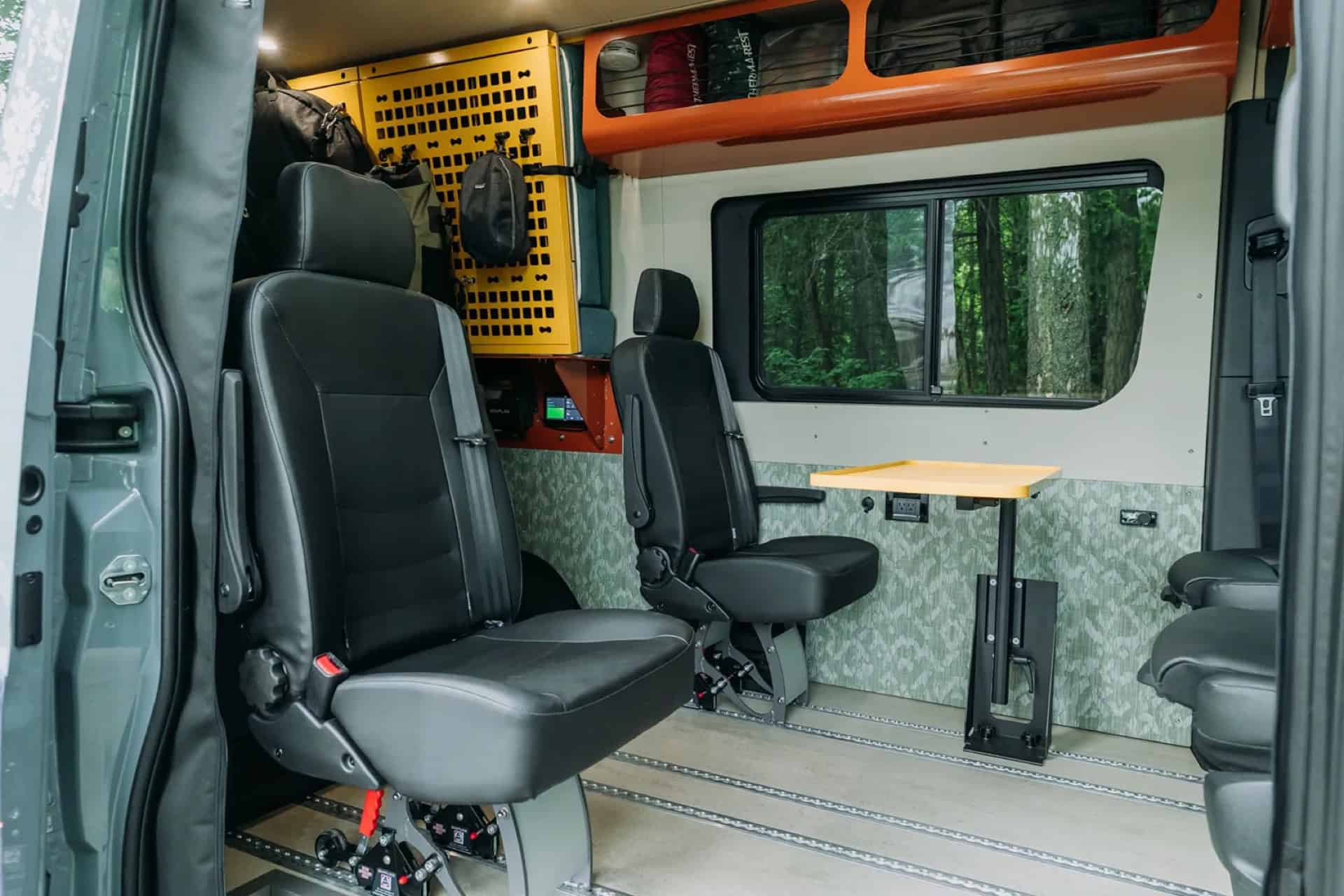GB01 rear captain's seats with a fold-down table and a yellow MOLLE gear panel on the wall