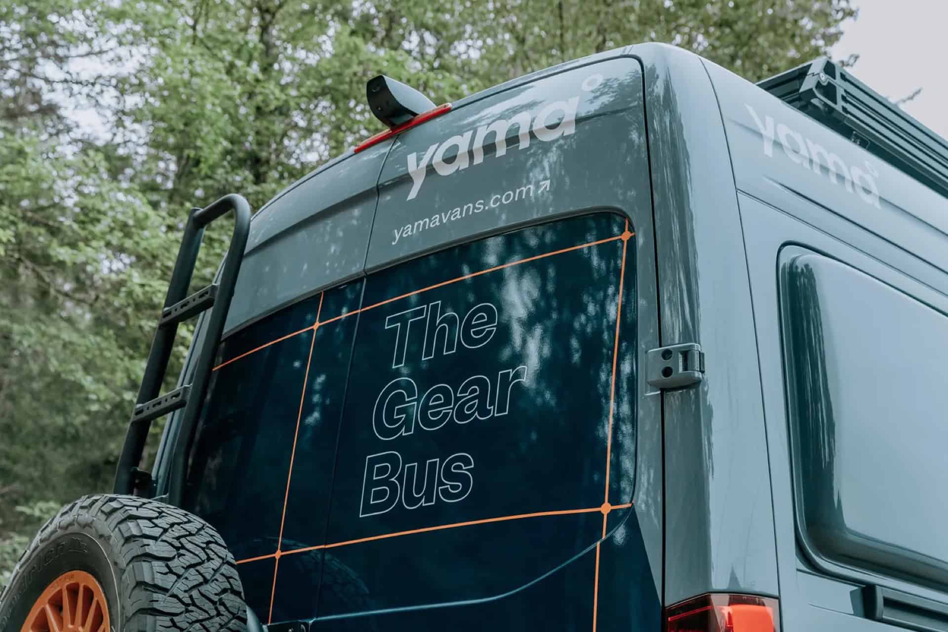 Rear of the GB01 Gear Bus showing the yama logo, The Gear Bus graphics, ladder, and spare tire