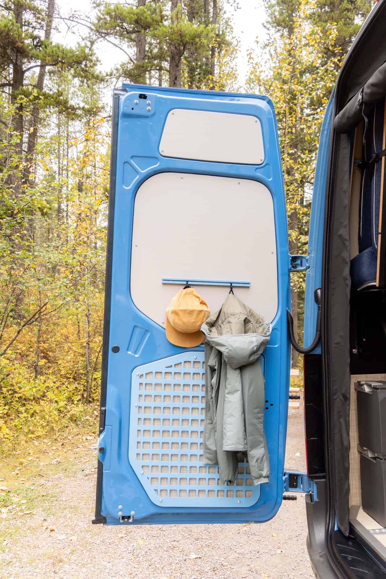 Rear door of the Peyto van fitted with a MOLLE panel holding a cap and a rain jacket