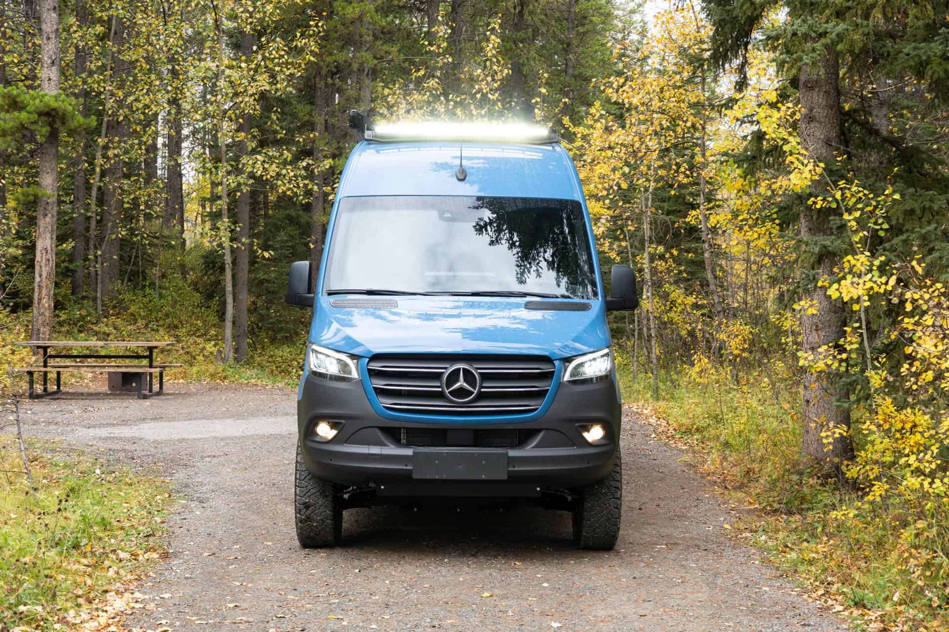 Front view of the blue Peyto Sprinter camper van showing the Mercedes grille and roof light bar