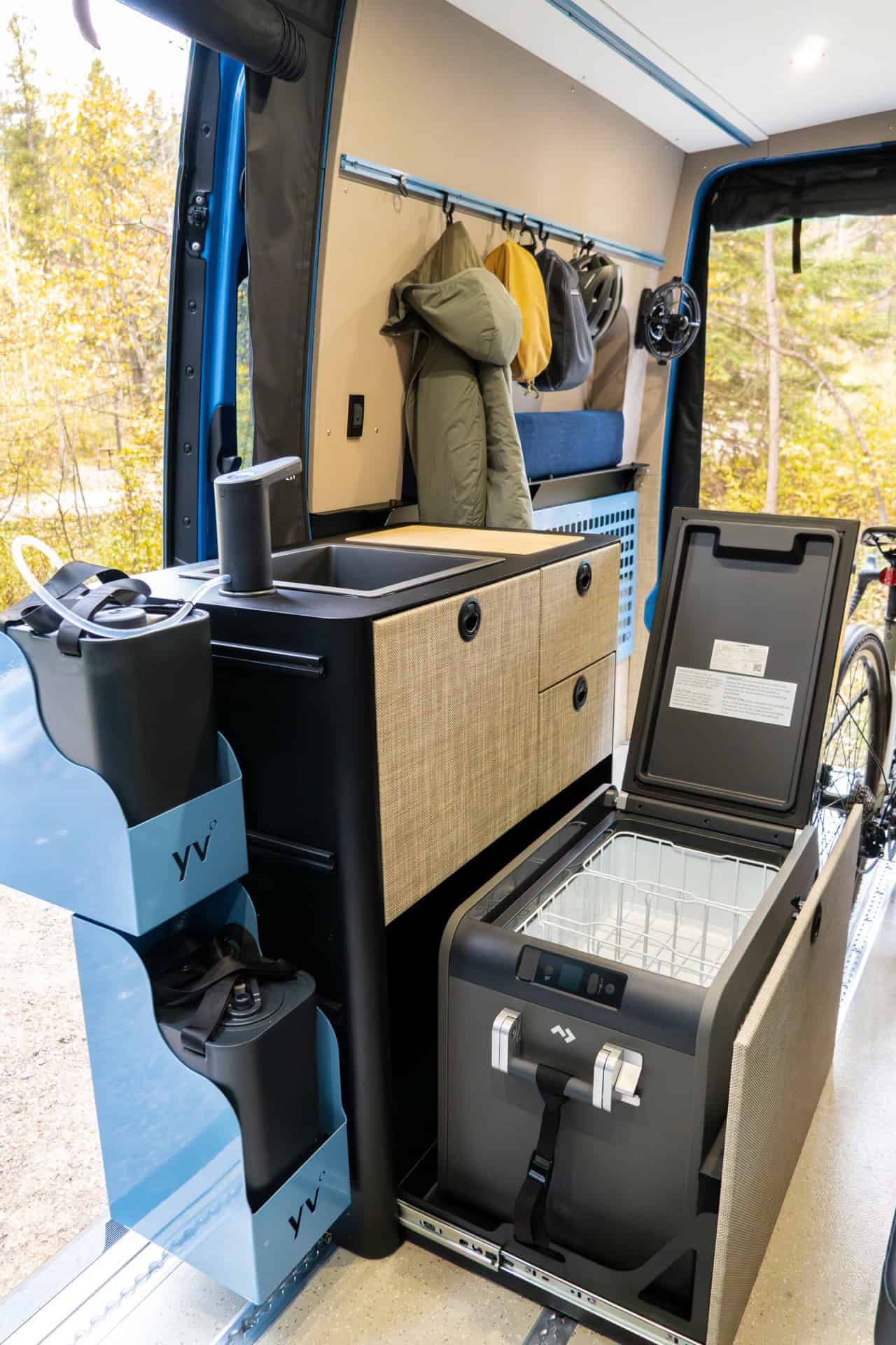 Compact Peyto galley with a bamboo-covered sink, cane-front cabinets, and a slide-out drawer fridge