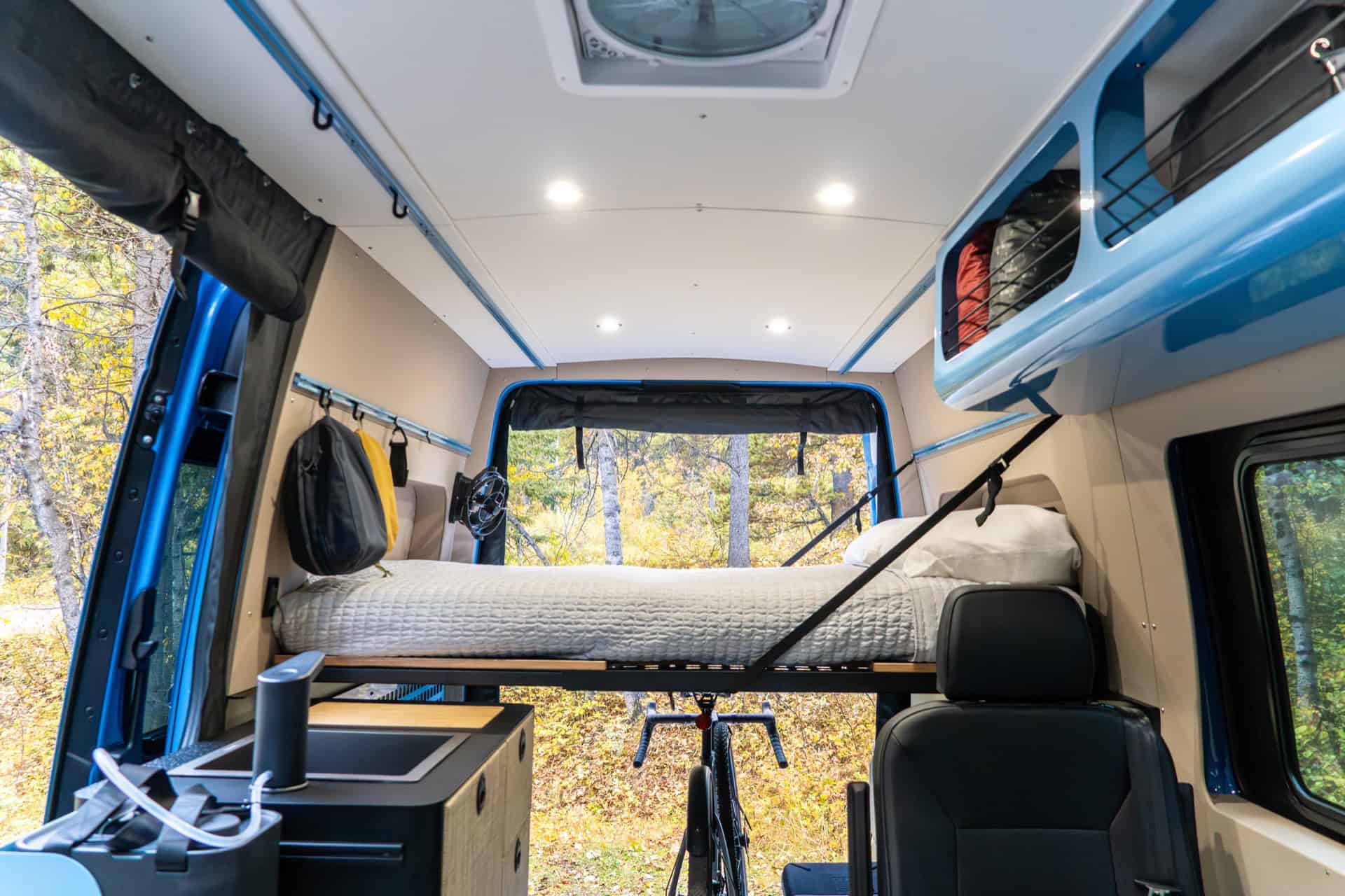 Murphy bed folded down across the Peyto camper van with a bicycle stored upright underneath