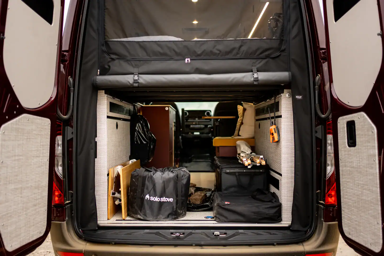 The rear gear garage of the Yama Vans Brio loaded with adventure gear beneath the elevated bed