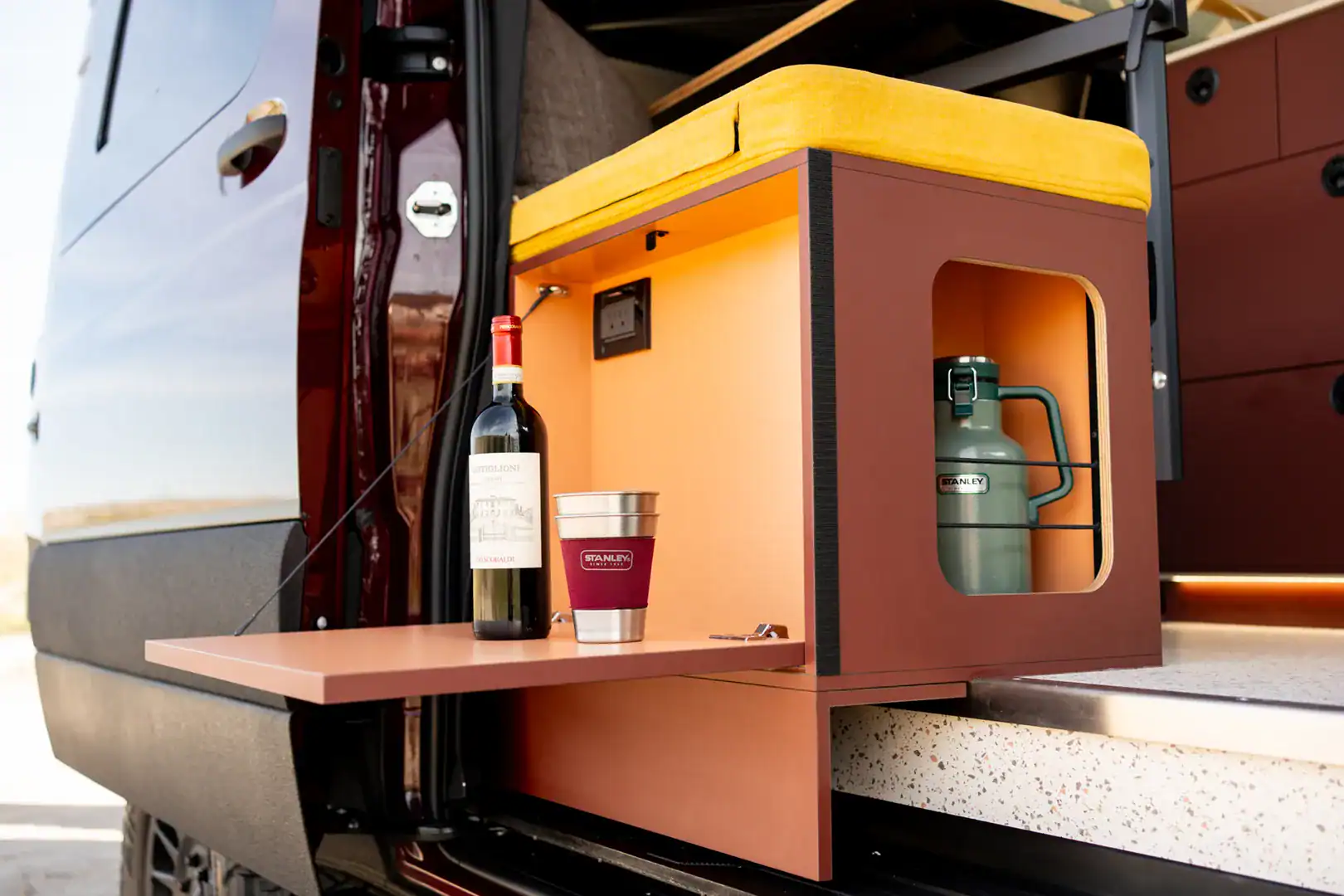 A swing-out rear prep surface on the Yama Vans Brio set up with drinks and a water jug